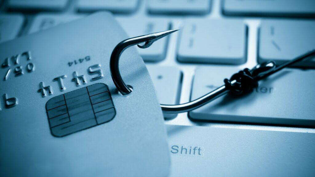 Eine Kreditkarte mit einem daran befestigten Haken. Symbolbild für Phishing.