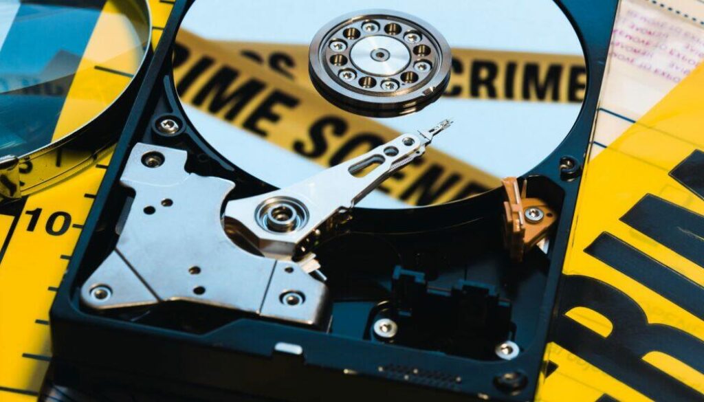Eine Festplatte mit einem Polizeiabsperrband um Cybercrime zu visualisieren.